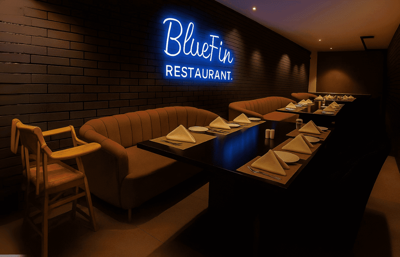 Cozy seating area at BlueFin Restaurant with brown sofas, a high chair, and a glowing neon sign reading “BlueFin Restaurant